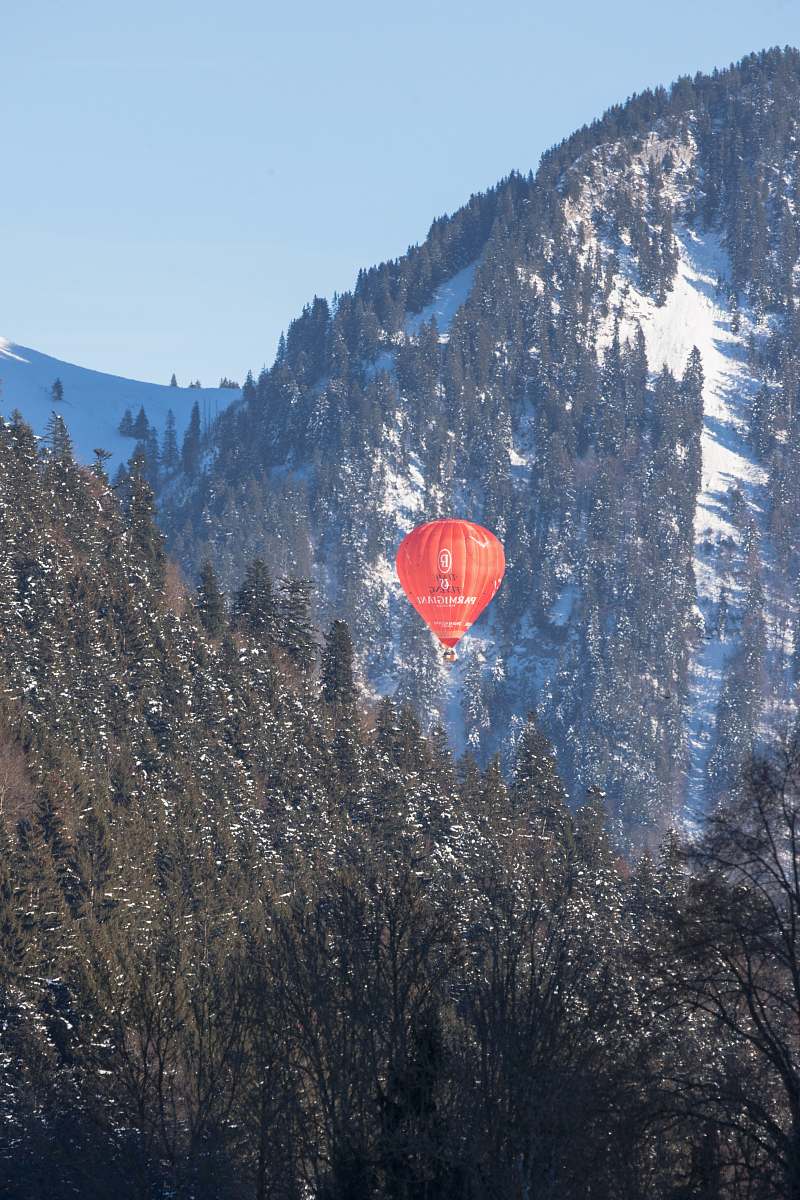 hot air balloon red air balloon between green mountains with trees ball